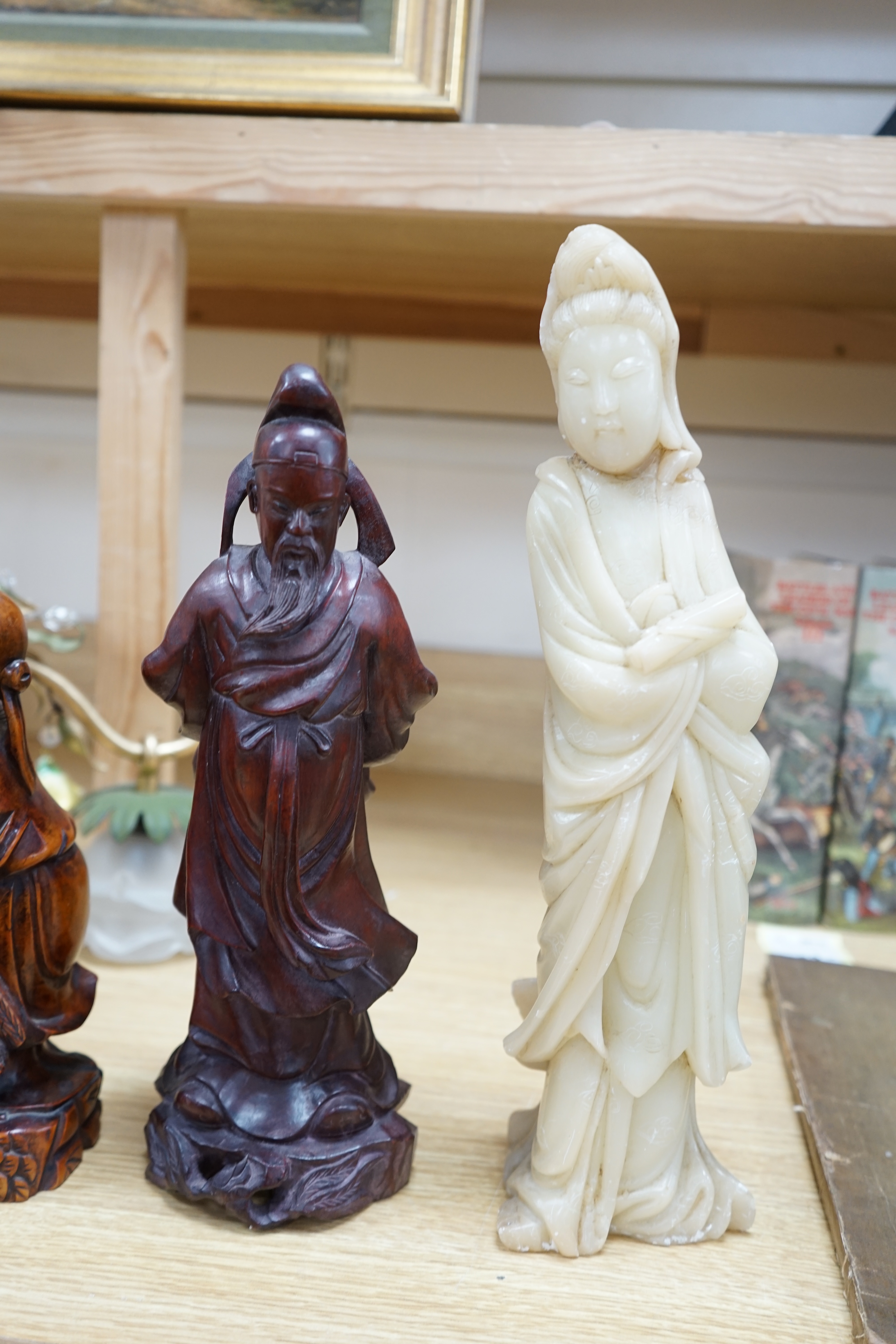 Two Chinese hardwood carved figures and a soapstone figure of Guanyin, largest 37cm high. Condition - fair